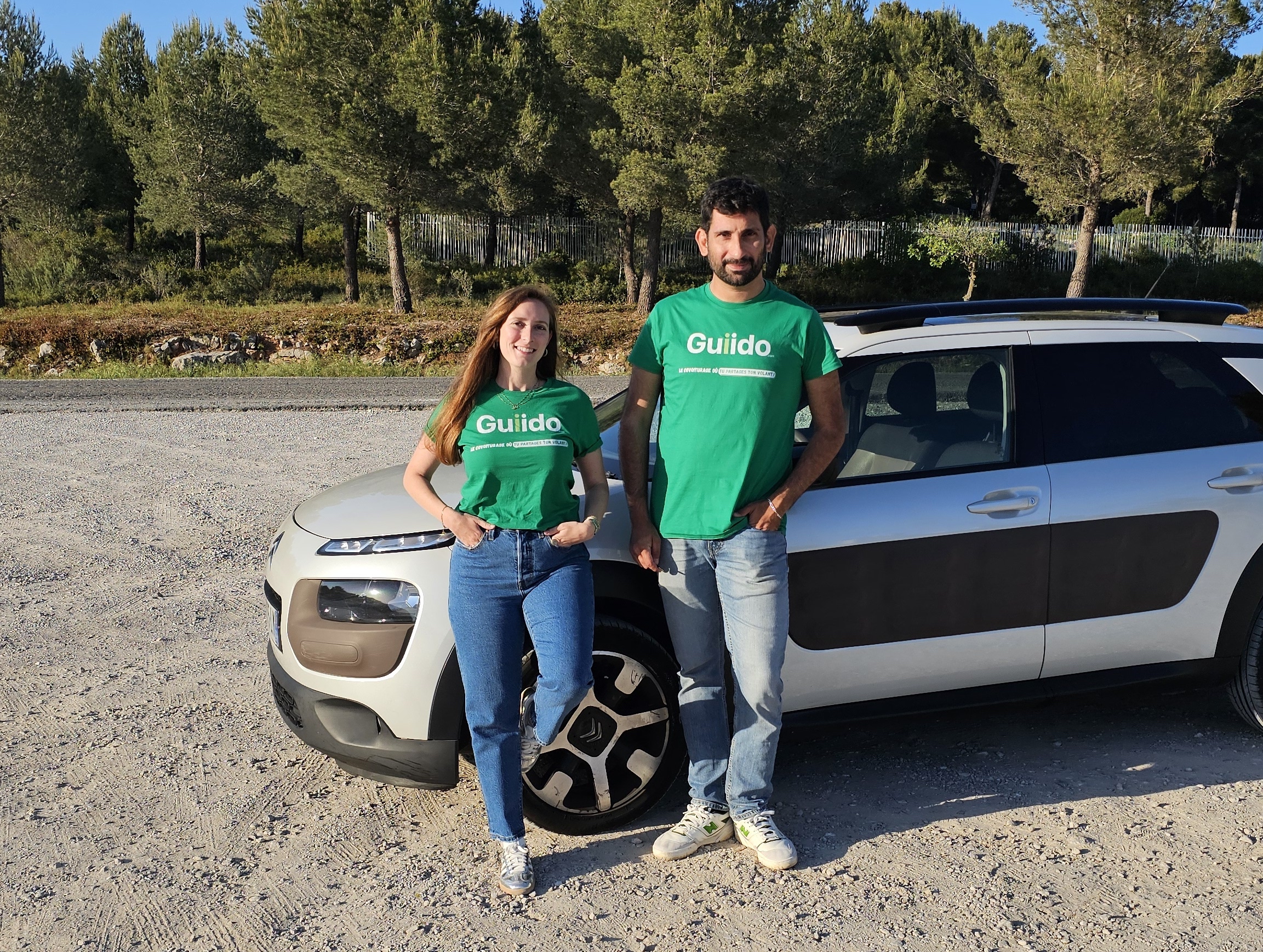 Alice et Enrico, cofondateurs de Guiido, devant leur voiture